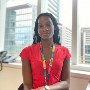 Dr. Amanda Morris smiling in a light office with a view of buildings behind her.